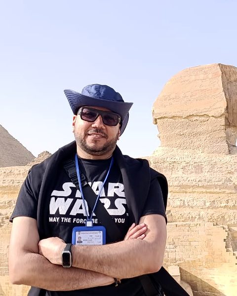 Michael Sabry smiling in front of the Great Sphinx and the Great Pyramid